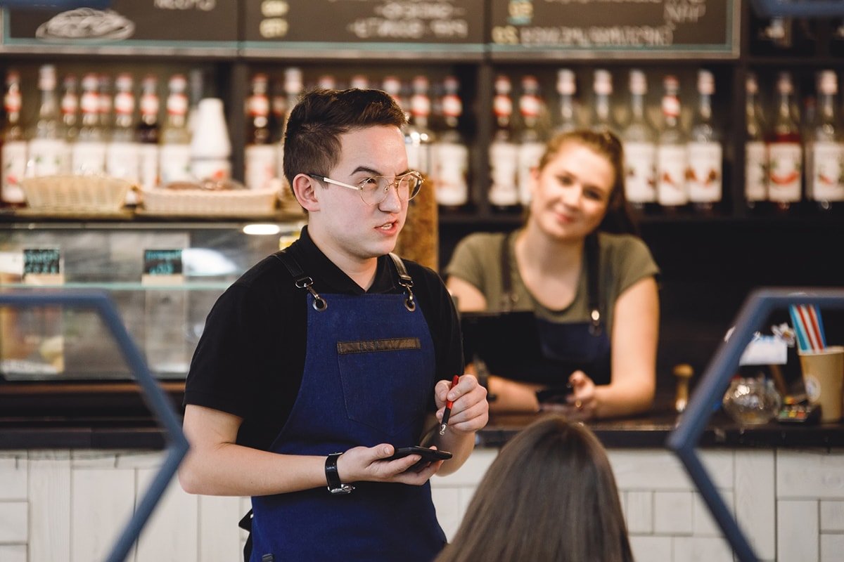 официант берет заказ в ресторане